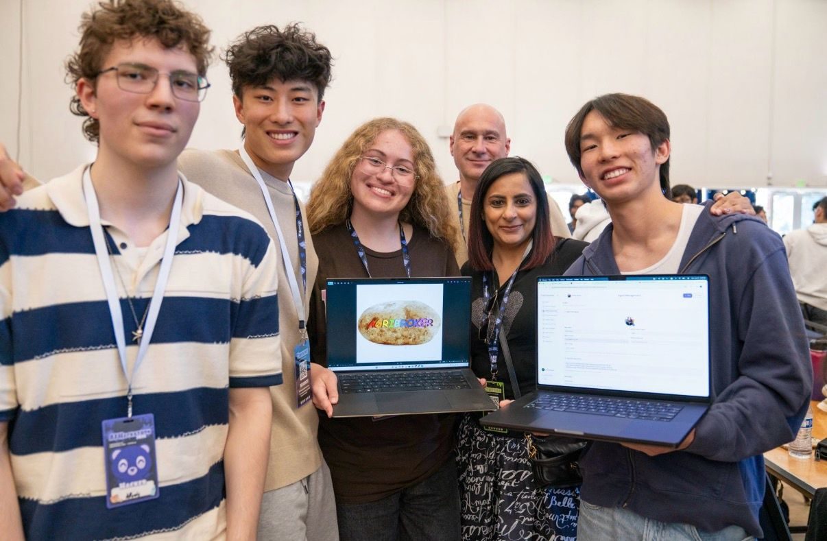 The AgriBroker team showing the project on two laptops